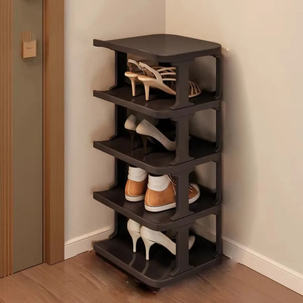 A dark gray stackable vertical shoe rack with four tiers holding various pairs of shoes.