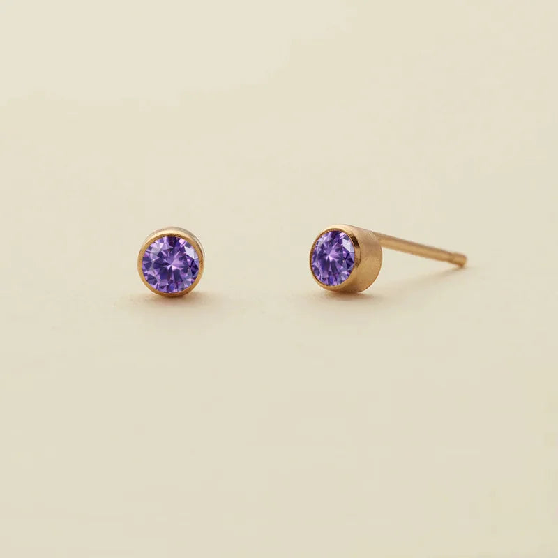 Boucles d'oreilles à clous minimalistes en améthyste violette et posts dorés.
