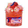 A clear plastic container filled with pink slime featuring a small dinosaur figure on top.