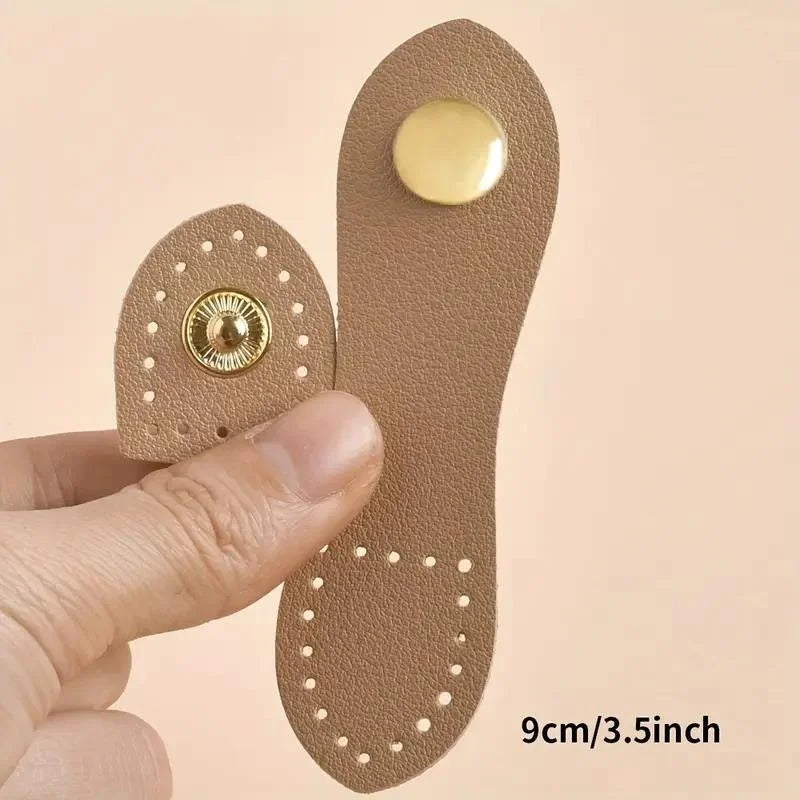 A set of eight brown leather buckle clasps with gold accents shown being held by a hand.