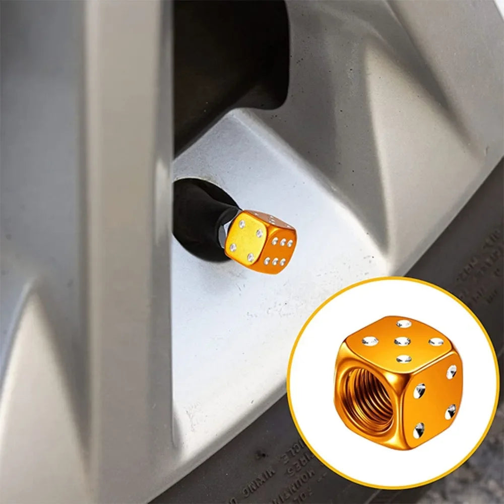 Close-up view of aluminum alloy dice design tire valve caps with gold accents.