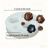 White silicone mold shaped like a lotus flower with several rose-colored silicone flower components.