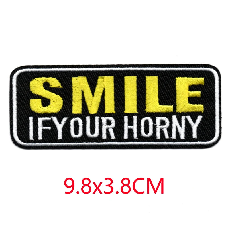 Black and yellow embroidered iron-on letter patch with the text SMILE IF YOUR HORNY