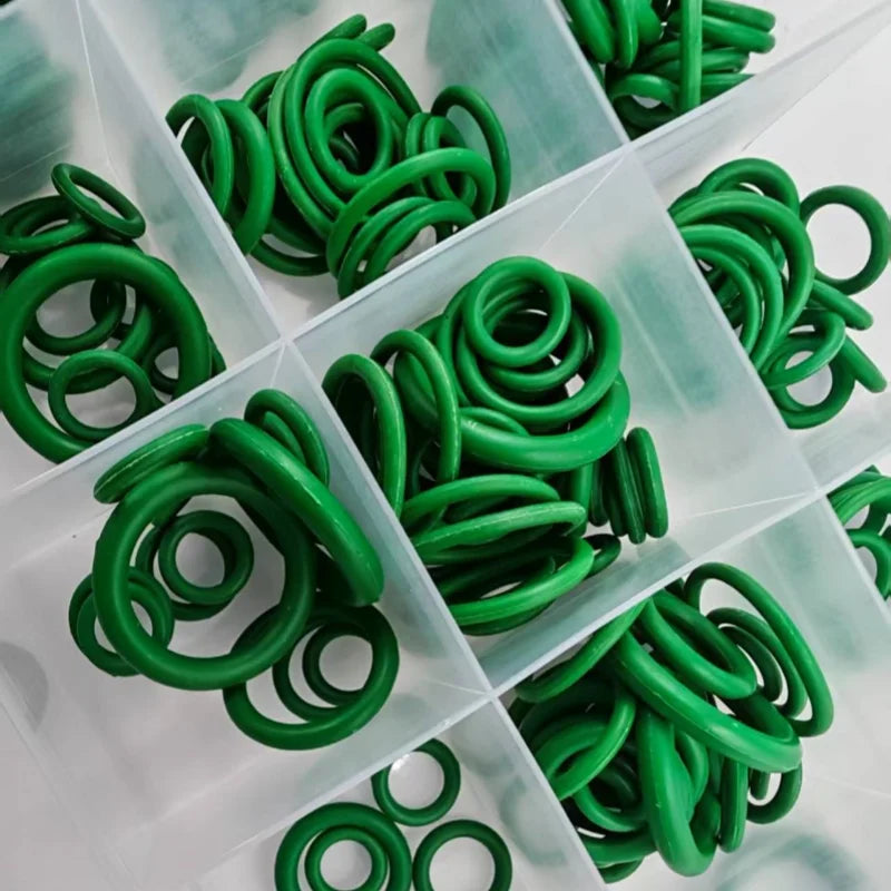 A collection of green automotive air conditioning O-ring gaskets packaged in a clear plastic tray.