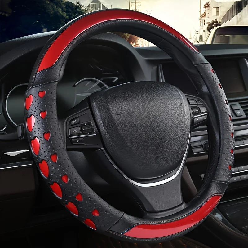 A close-up view of a black steering wheel with red heart-shaped accents and leather trim.