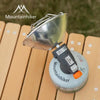 A silver portable butane gas stove with a flared cup is shown resting on a wooden surface.