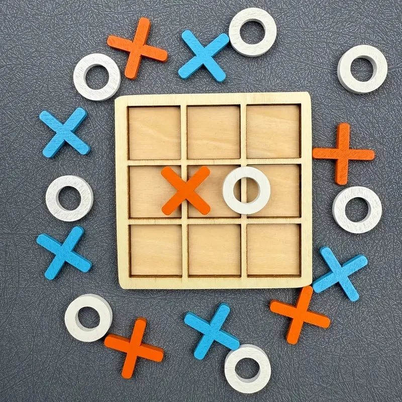 A wooden tic tac toe game set with various colored wooden and white circular and cross pieces scattered on a dark surface.