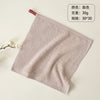 A light beige organic cotton face towel is shown flatly on a surface.