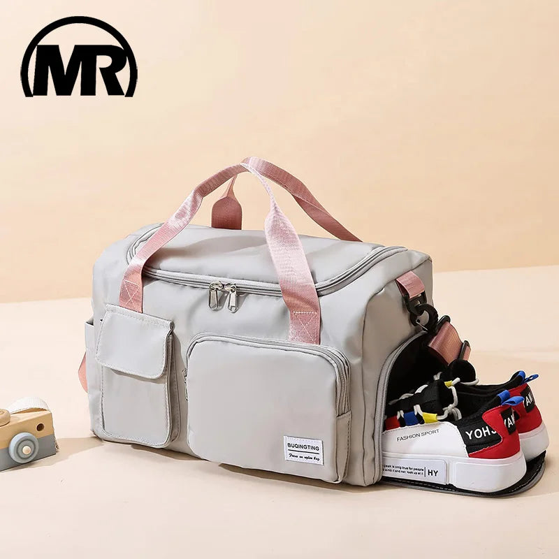 A light gray waterproof travel duffle bag with a shoe compartment is shown on a surface.