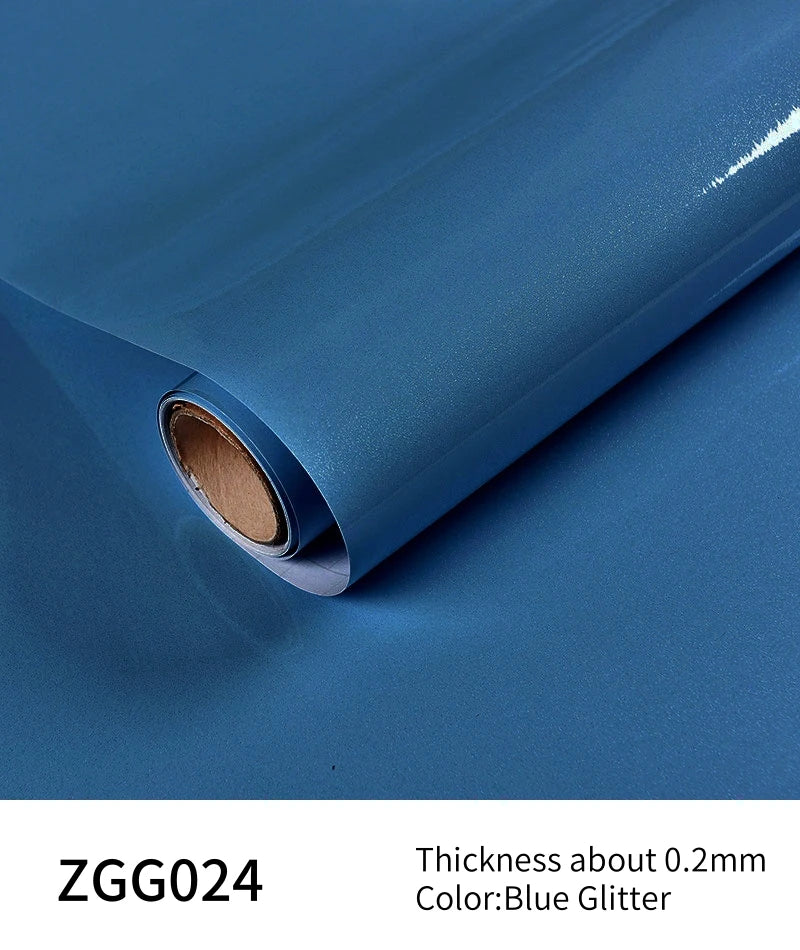 Blue glitter peel-and-stick vinyl contact paper rolled up showing its thickness and color
