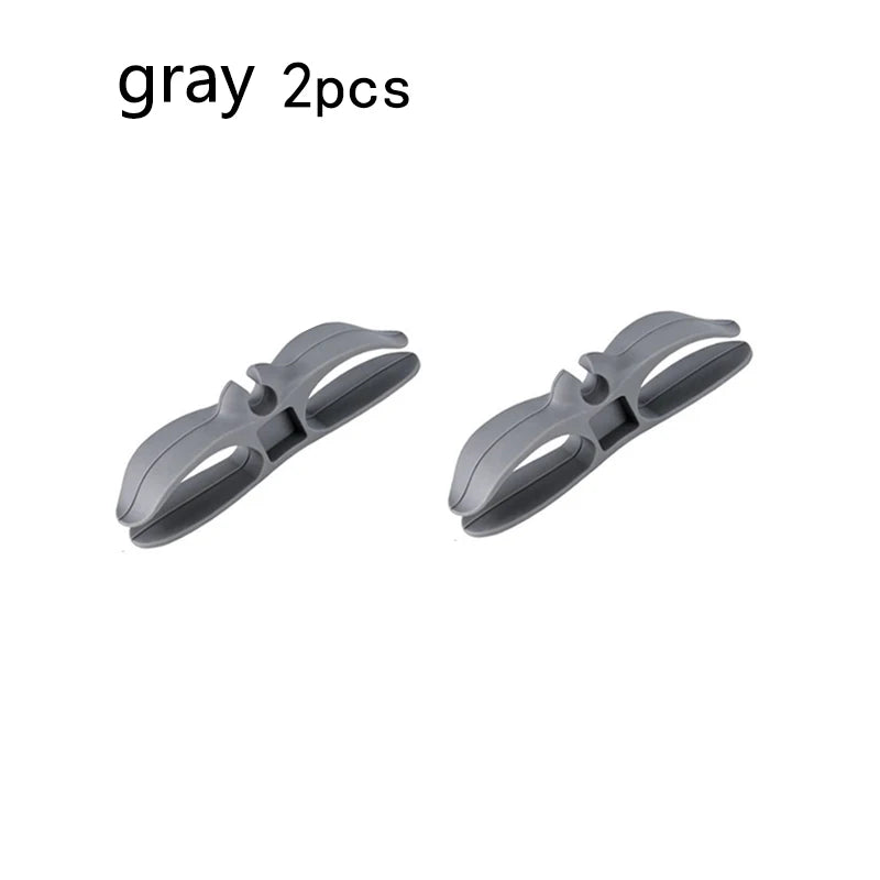 Two gray cord organizers or wire winders for tidy cable management.