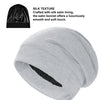 A light gray silk satin sleep bonnet rolled up, showing the smooth texture and soft finish.