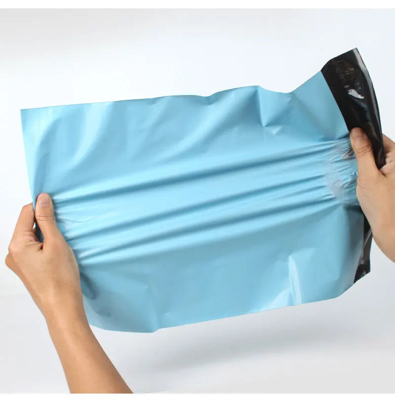 Hands holding a light blue heavy-duty waterproof poly mailer bag for shipping and storage