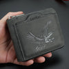 Dunkelgraves Leder-Kartenwallet mit silbernem Adler-Design in der Hand.
