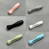 A collection of soft silicone pen grip sleeves in various pastel and neutral colors, including pink, gray, black, white, ligh