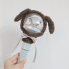 A plush cover shaped like a brown animal with long ears is shown being held, featuring a clear dome and a light stick base.