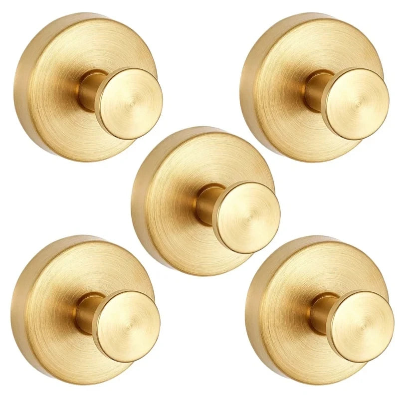 A set of two round, brass-toned suction cup hooks with a polished finish.