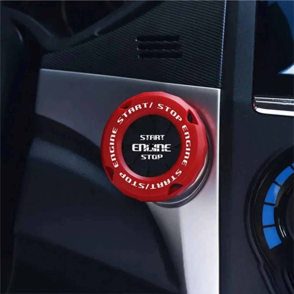 Close-up of a red rotating cover for a car ignition start button labeled Start/Stop Engine.