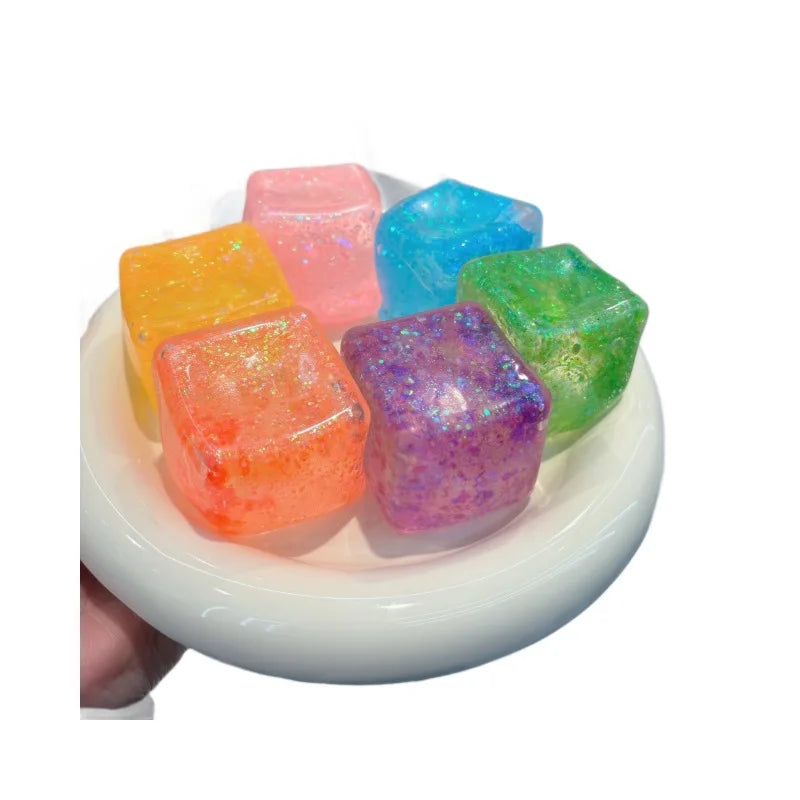 Eine Sammlung farbenfroher quadratischer Stressabbau-Fidget-Spielzeuge in rosa, blau, grün und lila auf einer weißen Schale.