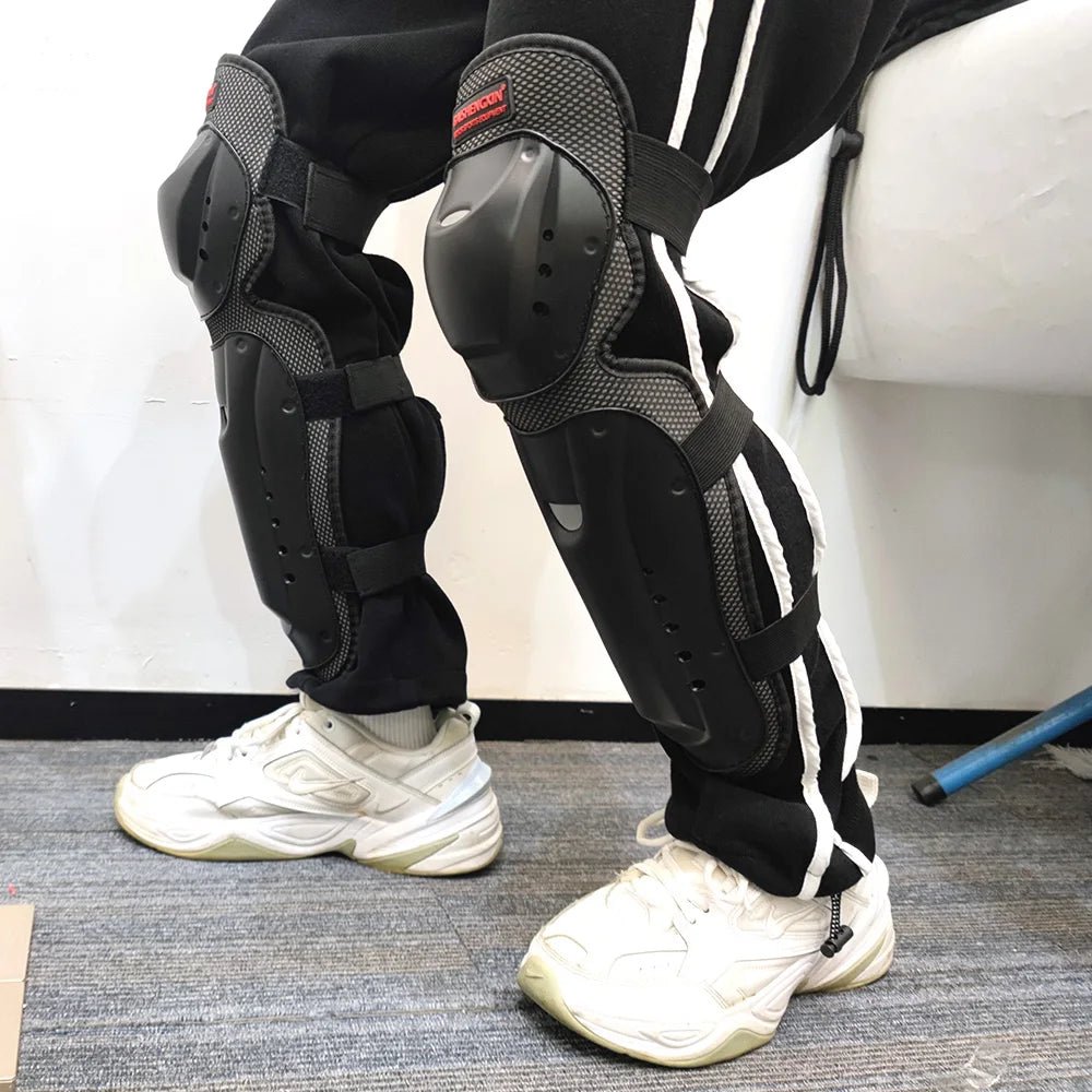 A person wearing black motorcycle knee and elbow protective pads with white sneakers.