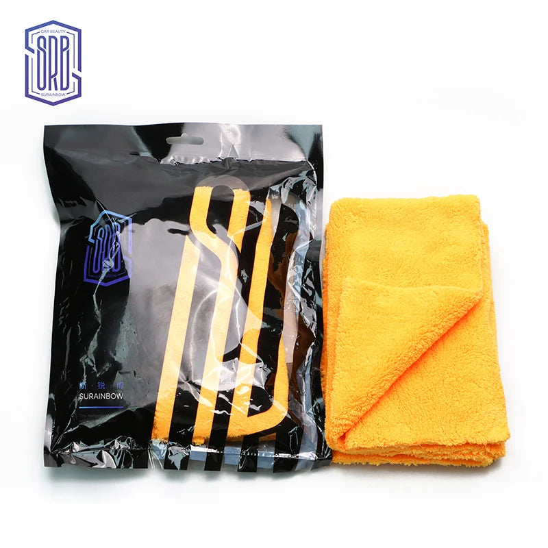 A black package of yellow reusable microfiber cleaning cloths next to a bright orange towel.
