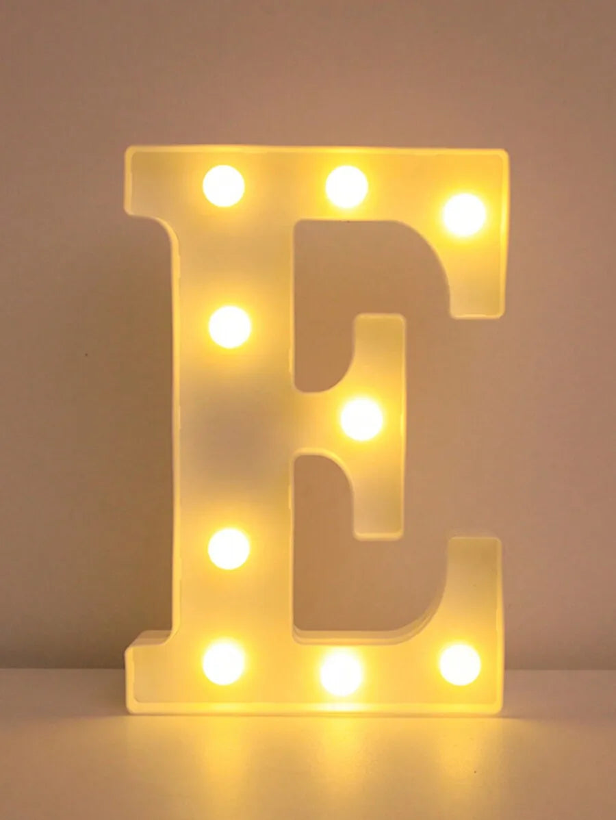 A glowing yellow LED letter E night light with illuminated dots, used for home and party decor.