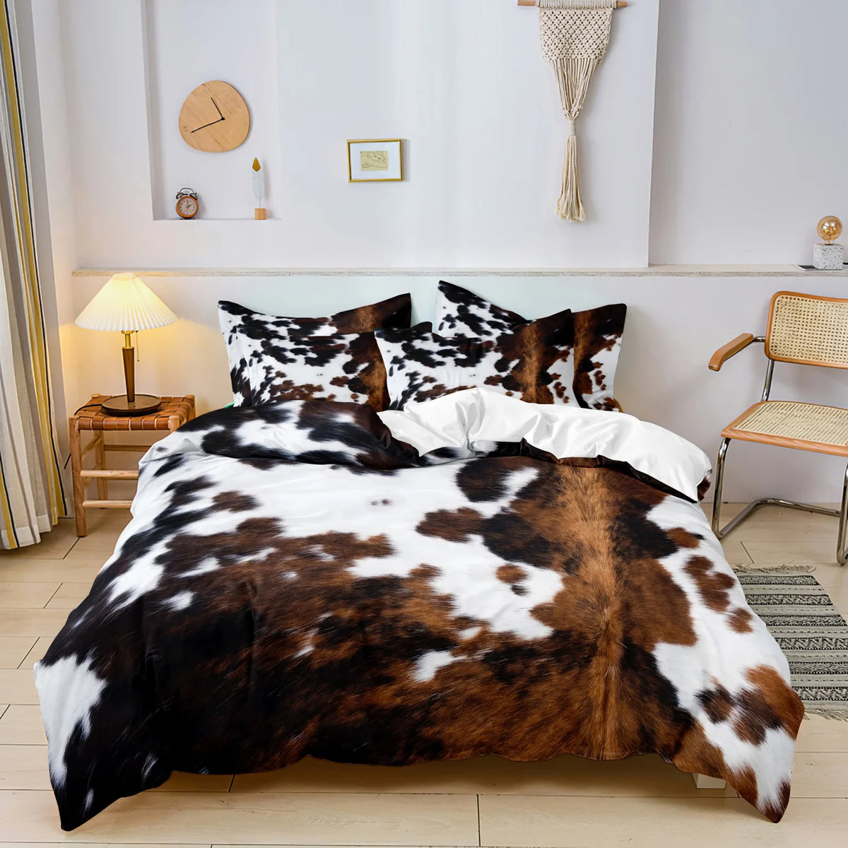 A cow print duvet cover set featuring black and white spots on a brown background displayed on a bed.