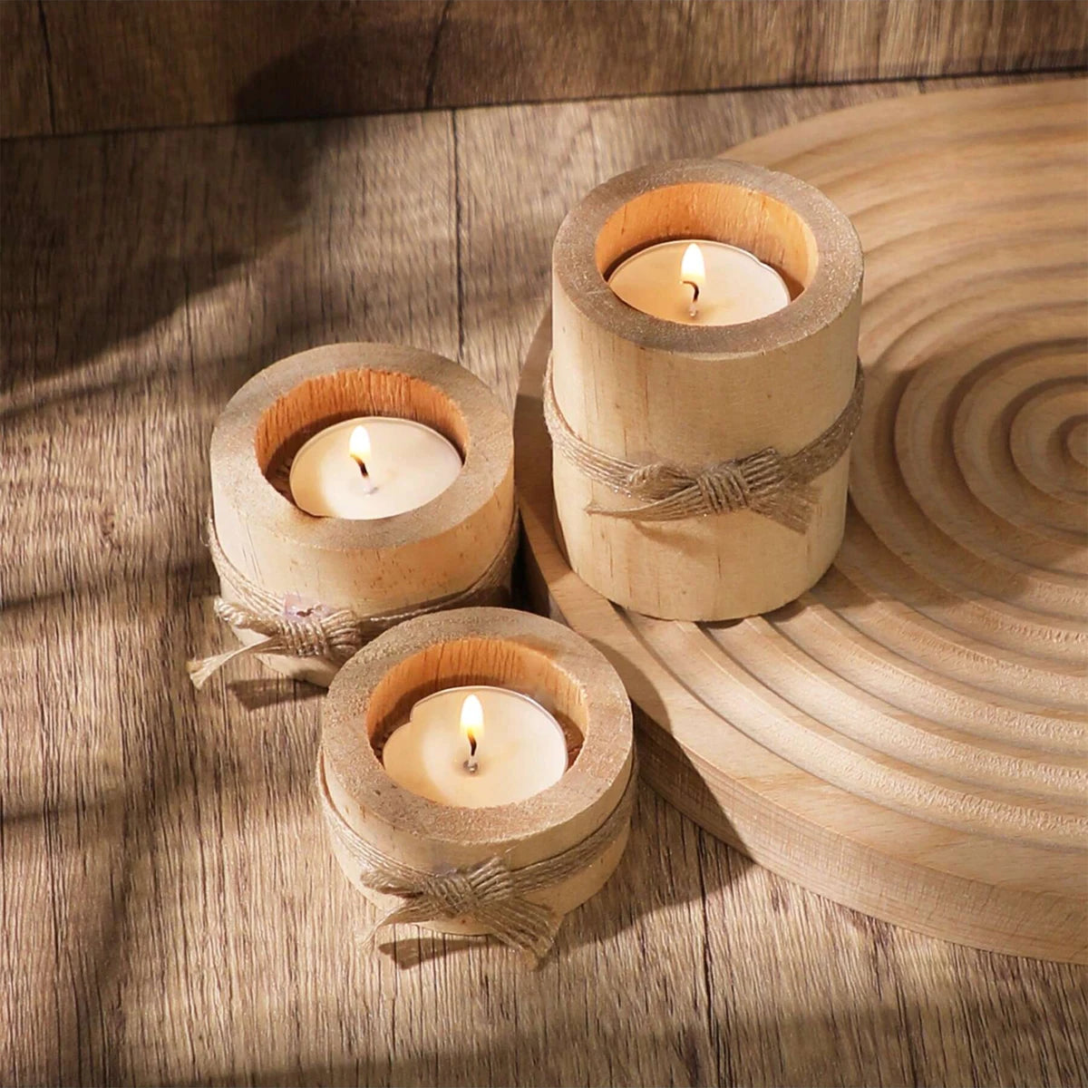 A rustic wooden tea light holder with a wick is placed on a round wooden platter.
