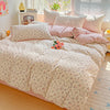 A pink floral duvet cover set with a matching flat sheet and pillows displayed on a bed.