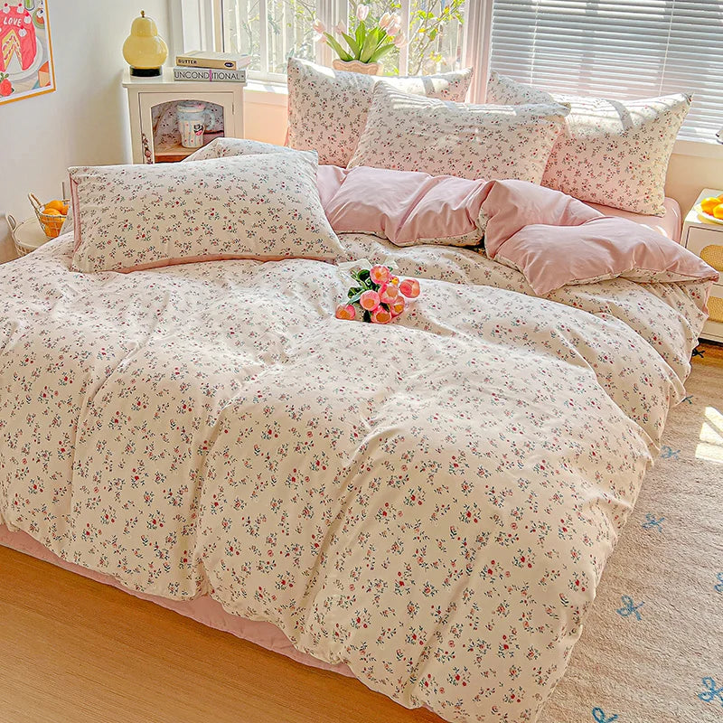 A pink floral duvet cover set with a matching flat sheet and pillows displayed on a bed.