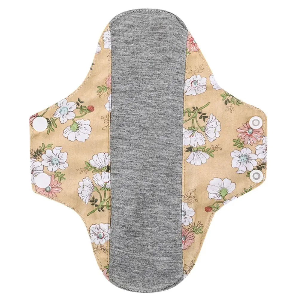 Reusable cotton menstrual pads featuring a beige background with a floral pattern and a gray absorbent core.