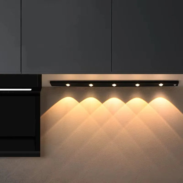 Iluminación bajo el gabinete que ilumina una encimera de cocina con un brillo cálido.