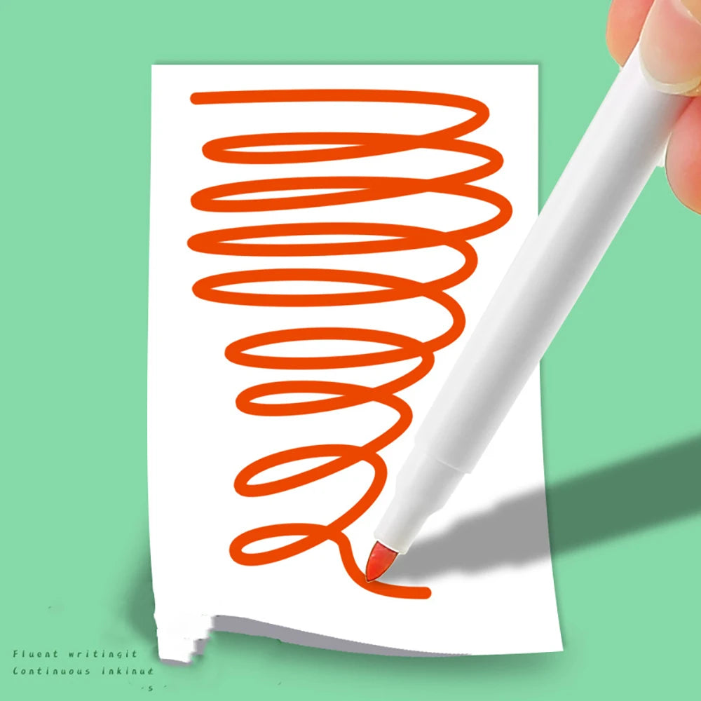 A hand holds a white marker drawing a bright orange spiral on a piece of white paper.