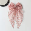 A sheer pink lace bow accessory for hair, resembling a sweet fairy style ponytail clip.