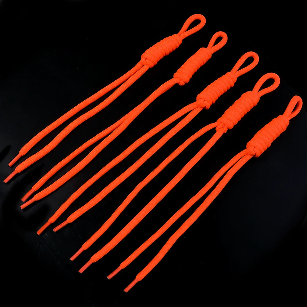 Five bright orange braided nylon lanyards or keychains arranged diagonally on a black background.