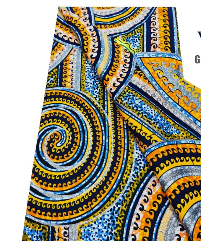 Close-up of a vibrant blue, yellow, and orange African wax print fabric with intricate swirling patterns.