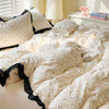 A bed dressed in French style polka dot bedding set with a duvet cover and pillowcases, featuring white fabric and black trim