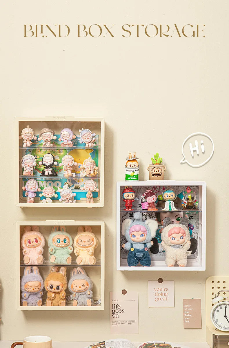 A wall-mounted display case showing various collectible dolls and figures in clear plastic packaging.