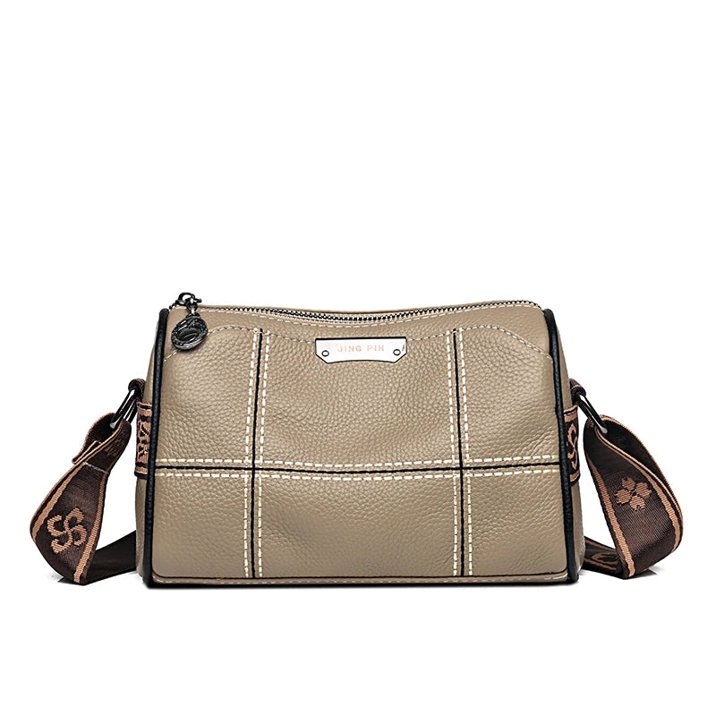 A beige vintage genuine leather women's shoulder bag with stitching and a leather tag.