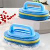 Blue and yellow sponge cleaning brush with a handle resting on a white box.