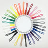 A circular arrangement of 50 colorful plastic zipper pulls in various shades of green, pink, yellow, and black.