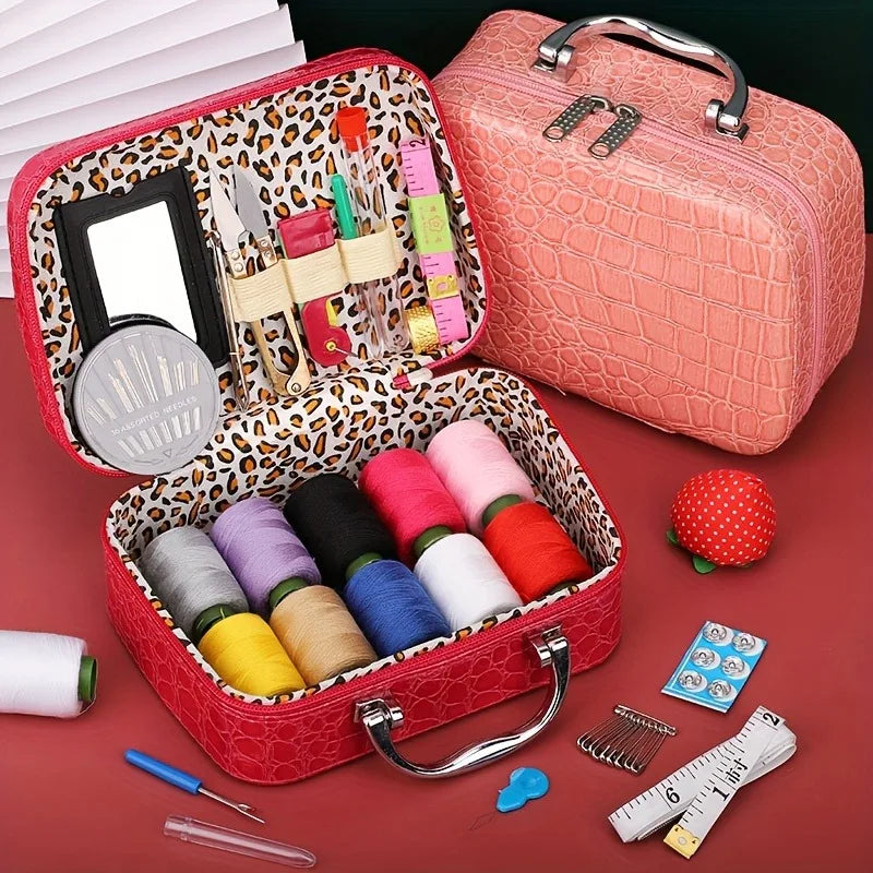 A pink faux leather sewing kit box containing various sewing tools like needles, thread, and measuring tools.