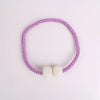 A purple braided tie-back clip featuring small white pearls.