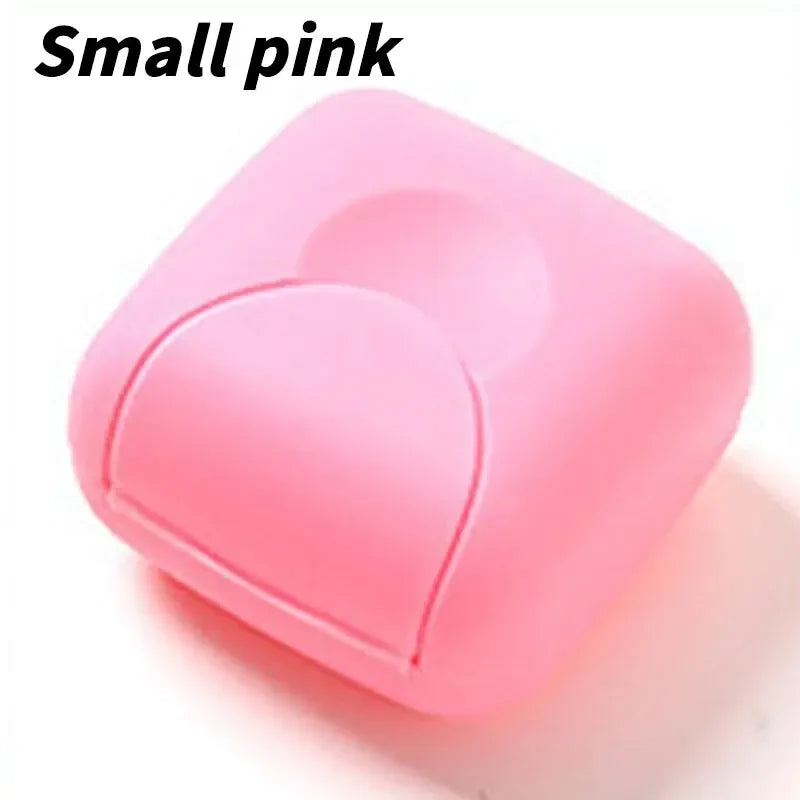 A small pink portable soap holder with a rounded lid shown in a close-up view.