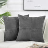 A set of two gray corduroy patchwork throw pillow covers displayed on a white sofa.