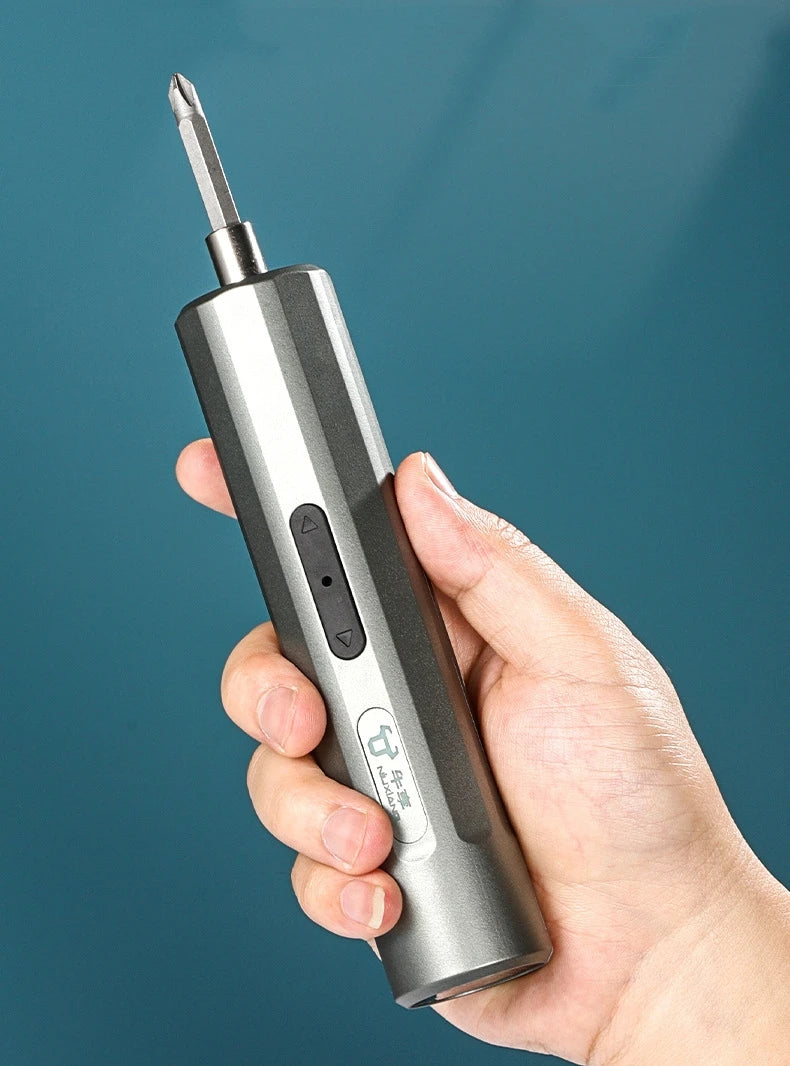 A hand holds a silver cordless electric screwdriver with a sharp tip and a button, against a dark blue background.
