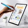 A hand holds a blue stylus pen writing on an iPad screen displaying a color design plan.