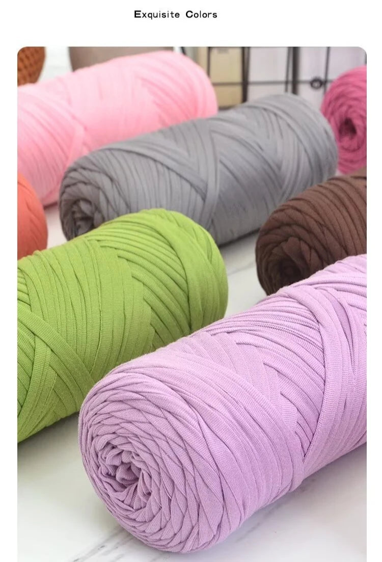A collection of thick, colorful yarn skeins in shades of pink, green, gray, and purple for knitting and crochet projects.