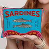 A vintage canvas cosmetic bag featuring a graphic print of sardines on a teal background.