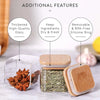 Square glass spice jars with bamboo lids and labels shown next to dried spices on a white surface